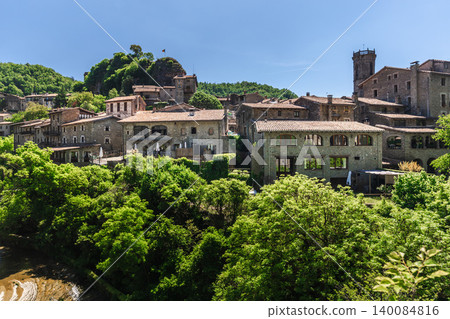 Historic stone houses of Rupit village in Catalonia, Spain, surrounded by lush forest and dramatic rocky hillside Historic stone houses of Rupit village in Catalonia, Spain, surrounded by lush forest and dramatic rocky hillside 140084816