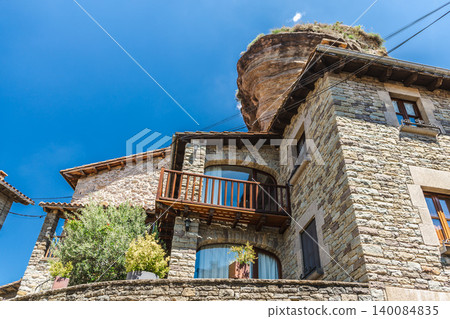 Stone house built beneath dramatic rock formation in Rupit village, Catalonia, Spain Stone house built beneath dramatic rock formation in Rupit village, Catalonia, Spain 140084835