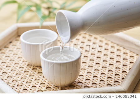 A set of sake carafe and sake cups, representing the act of pouring sake. 140085041