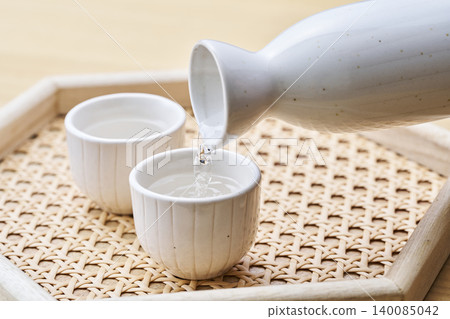 A set of sake carafe and sake cups, representing the act of pouring sake. 140085042