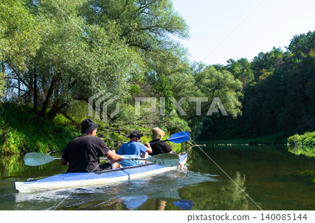 Family with child paddling Vuoksa kayak on the river, family water tourism, nature journey. Family with child paddling Vuoksa kayak on the river, family water tourism, nature journey. 140085144