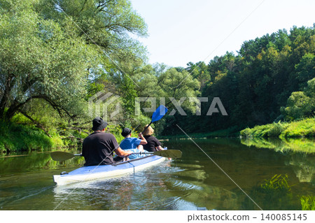 Parents and child in a Vuoksa kayak, family water trip on the river, shared nature adventure. Parents and child in a Vuoksa kayak, family water trip on the river, shared nature adventure. 140085145