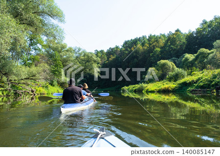 Parents and child on a Varzuga kayak during a family paddle, joint trip and summer tourism. 140085147