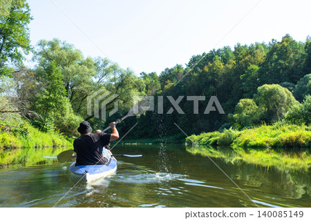 Family team in a Varzuga kayak paddling on a winding river, shared water route, health and unity. Family team in a Varzuga kayak paddling on a winding river, shared water route, health and unity. 140085149