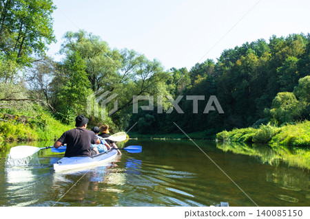 Family moving in a Vuoksa kayak on the river, family water vacation with children, active rest. Family moving in a Vuoksa kayak on the river, family water vacation with children, active rest. 140085150