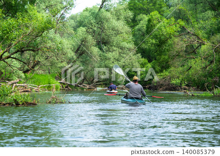 Man paddling kayak alone, exploring wild river nature, solo active adventure, scenic summer water tourism. 140085379