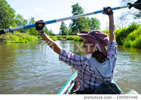 Woman with paddle kayaking on sunny river, outdoor active sport, summer vacation, adventure gear, travel tourism recreation. Woman with paddle kayaking on sunny river, outdoor active sport, summer vacation, adventure gear, travel tourism recreation. 140085446