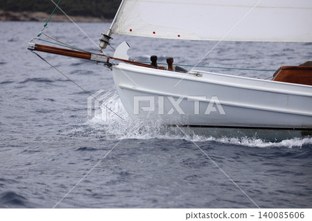 Close up on the bow of a sailboat breaking through a wave Close up on the bow of a sailboat breaking through a wave 140085606