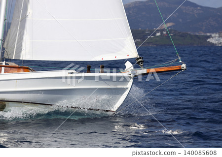 Close up on the bow of a sailboat breaking through a wave Close up on the bow of a sailboat breaking through a wave 140085608