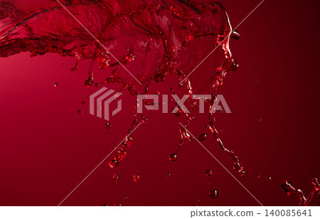 Glass and red wine splash on a dark red background. Glass and red wine splash on a dark red background. 140085641