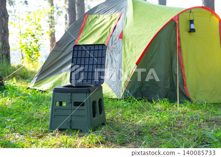 Portable toilet placed near camping tent, outdoor hygiene and comfort for wild travel, modern sanitation facility, tourism area application. Portable toilet placed near camping tent, outdoor hygiene and comfort for wild travel, modern sanitation facility, tourism area application. 140085733