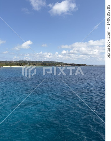 A beautiful emerald green sea and cape under a summer blue sky and white clouds. A beautiful emerald green sea and cape under a summer blue sky and white clouds. 140085885