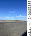 A vast expanse of blue sky and an asphalt runway 140085886
