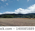A peaceful rural landscape of vast fields after harvest and rolling green mountains. 140085889