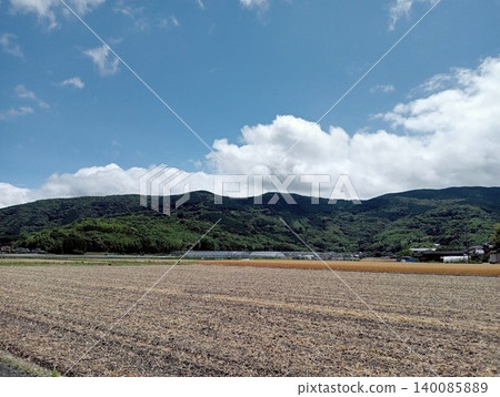 豐收後的廣闊田野和起伏的青山,構成了一幅寧靜祥和的鄉村景象。 豐收後的廣闊田野和起伏的青山,構成了一幅寧靜祥和的鄉村景象。 140085889