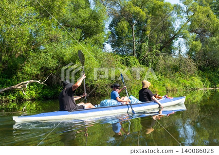 Family in the Varzuga kayak paddling the river, active summer water adventure, teamwork, healthy recreation, leisure for parents and kids. 140086028