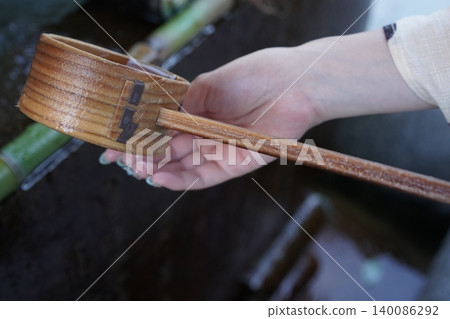 用湯匙在淨水池舀水。 用湯匙在淨水池舀水。 140086292