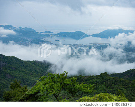 Misty panoramic landscape of Shodoshima Island with Seto Inland Sea, mountain ridges and drifting clouds. Misty panoramic landscape of Shodoshima Island with Seto Inland Sea, mountain ridges and drifting clouds. 140086373