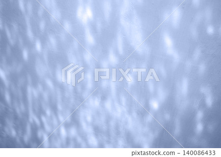 Soft blue light reflections on a textured wall creating an abstract calming background for design 140086433