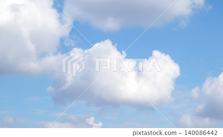 Fluffy white cloud floating in a bright blue sky over a calm summer atmosphere Fluffy white cloud floating in a bright blue sky over a calm summer atmosphere 140086442