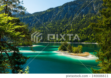 Travel landscape of Eibsee lake in Zugspitze Alps and island in mountains in Bavaria, Germany, scenic summer nature panorama with forest Travel landscape of Eibsee lake in Zugspitze Alps and island in mountains in Bavaria, Germany, scenic summer nature panorama with forest 140086611