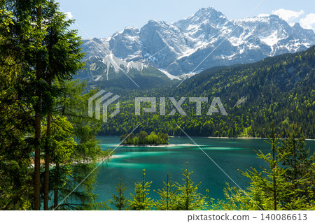 Travel landscape of Eibsee lake and island and Zugspitze mountain peak in Alps in Bavaria, Germany, scenic summer nature panorama with forest, snow mountains peak Travel landscape of Eibsee lake and island and Zugspitze mountain peak in Alps in Bavaria, Germany, scenic summer nature panorama with forest, snow mountains peak 140086613