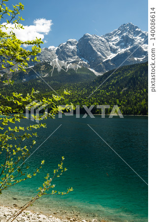 Travel landscape of Eibsee lake beach and Zugspitze peak in Alps, Bavaria, Germany, scenic summer nature panorama with forest 140086614