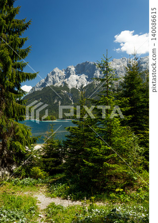 Travel landscape of Eibsee lake in Alps in Bavaria, Germany, scenic summer nature panorama with forest, mountains peak 140086615