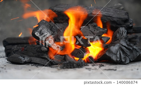 Close-up of Fiery Charcoal Embers and Bright Orange Flames 140086874