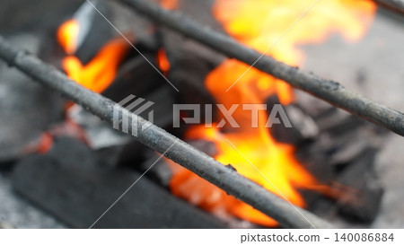 Vibrant Burning Charcoal Fire Through BBQ Grill Grate Vibrant Burning Charcoal Fire Through BBQ Grill Grate 140086884