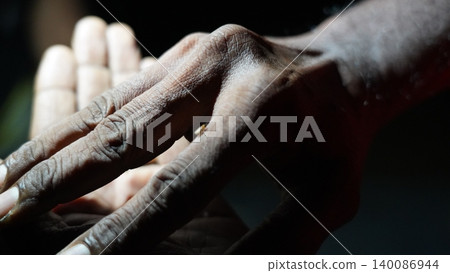 Deeply Textured Hands Bathed in Light and Shadow 140086944