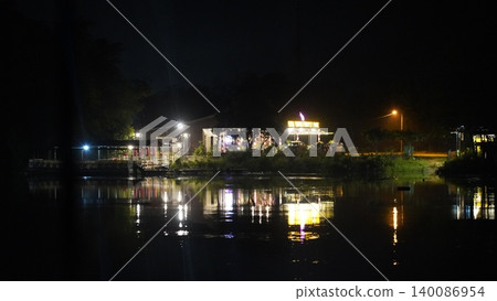 Illuminated Riverside Park at Night with Water Reflections Illuminated Riverside Park at Night with Water Reflections 140086954