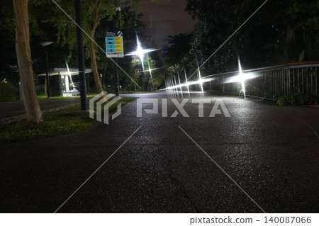 Nighttime park path lit by streetlights dark ambiance 140087066