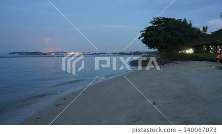 Serene Dusk on a Tropical Beach with Cityscape Glow Serene Dusk on a Tropical Beach with Cityscape Glow 140087073