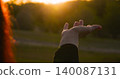 woman hand reaches out sunlight against natural backdrop, expressing freedom, hope and harmony. sunlight reflects inner strength, spiritual awakening and connection with nature. 140087131