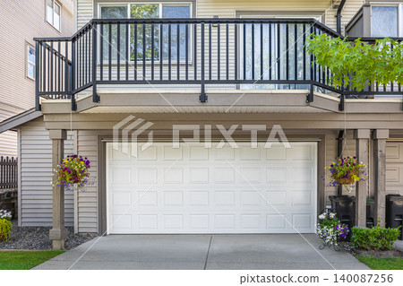 New wide garage door with concrete driveway of residential house. Real estate exterior front house New wide garage door with concrete driveway of residential house. Real estate exterior front house 140087256