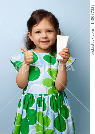 Happy little girl endorsing a product with a cheerful expression and showing thumbs up 140087322