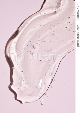Clear cosmetic gel spreading on pink background 140087378