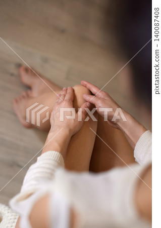 Person rubbing knee due to pain, joint ache, or injury. Addressing health, orthopedic issues, or muscle discomfort 140087408