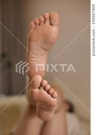 Human feet soles highlighting details of skin, toes, and heels, conveying concepts of care, relaxation, and anatomy Human feet soles highlighting details of skin, toes, and heels, conveying concepts of care, relaxation, and anatomy 140087409