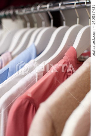 Clothing on hangers organizing a casual wardrobe, featuring shirts, sweaters, and blouses in various colors and styles Clothing on hangers organizing a casual wardrobe, featuring shirts, sweaters, and blouses in various colors and styles 140087433