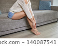woman massaging her tired legs and feet, suffering from pain, swelling, and varicose veins 140087541