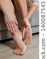 close-up of woman tenderly massaging her tired feet, applying pressure to the ankle and heel, finding comfort and relief 140087545