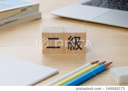 桌子上堆放著一疊積木,上面寫著「2 級」——象徵著獲得資格證書。 桌子上堆放著一疊積木,上面寫著「2 級」——象徵著獲得資格證書。 140088173