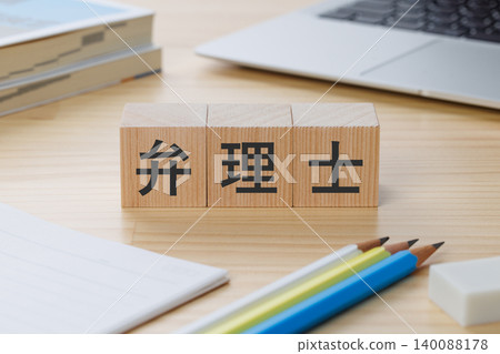 桌子上堆放著一疊積木,上面寫著「專利律師」——象徵著獲得該資格。 桌子上堆放著一疊積木,上面寫著「專利律師」——象徵著獲得該資格。 140088178