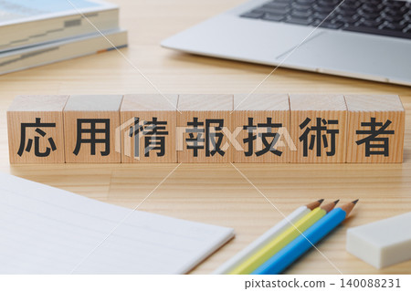 桌子上堆放著一疊積木，上面寫著「應用資訊科技工程師」——這是獲得該資格的象徵。 140088231