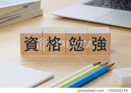 桌上堆放著一疊積木,上面寫著「學習考取資格證書」——象徵著取得資格證書。 桌上堆放著一疊積木,上面寫著「學習考取資格證書」——象徵著取得資格證書。 140088244