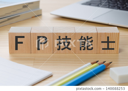 桌子上堆放著一疊積木，上面寫著「FP技能專家」——這是獲得資格的象徵。 140088253