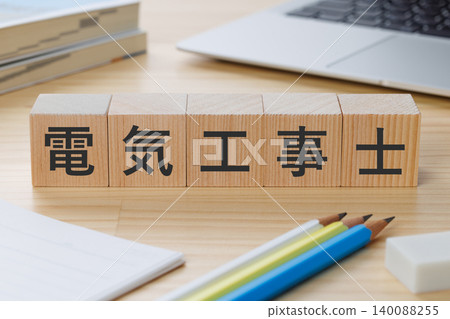 A stack of building blocks on a desk with the words "Electrician" written on it – an image of obtaining the qualification. 140088255