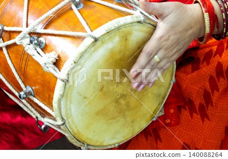 Woman Playing Traditional Dhol Drum During Indian Cultural Celebration 140088264